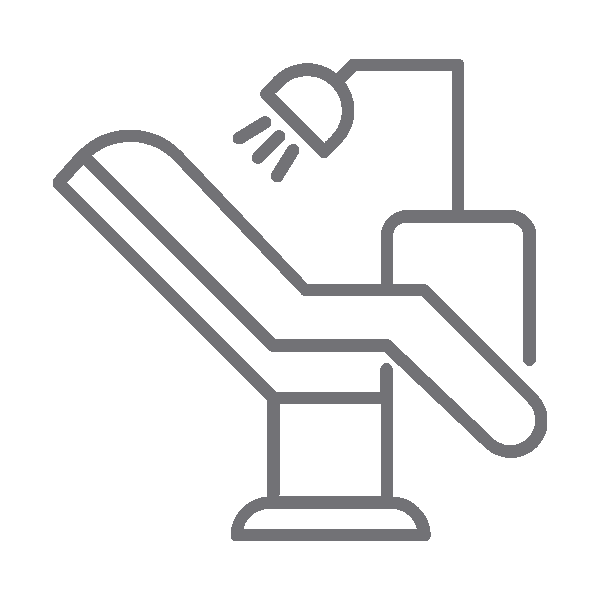 Dental chair with overhead light and suction tool in modern dental office setting.